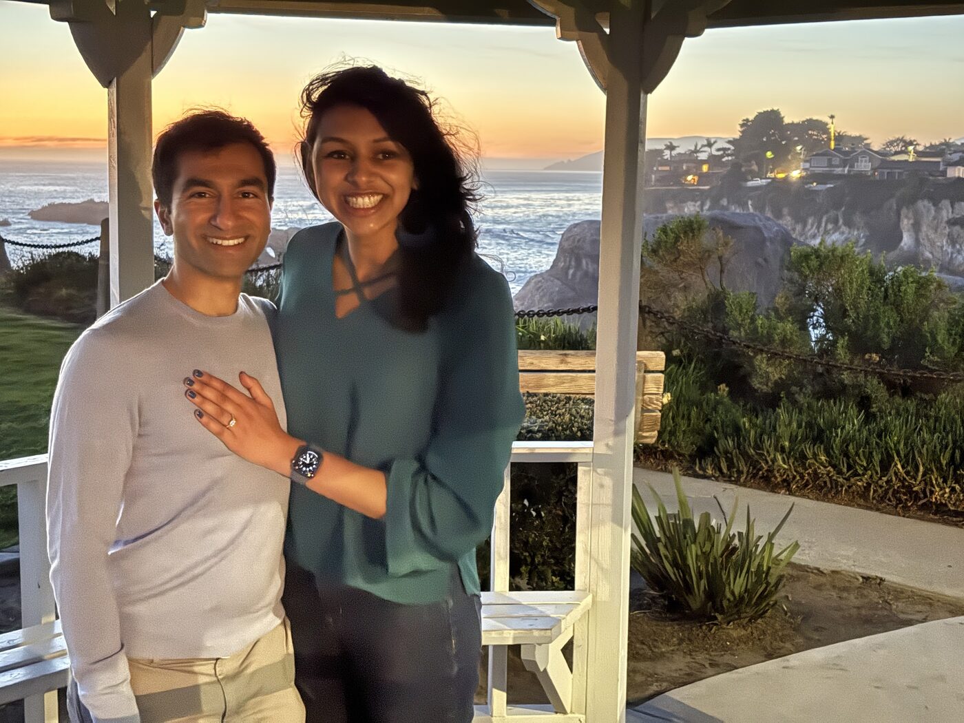 Rishi and Esha at a clifftop gazebo at sunset, moments after the first proposal